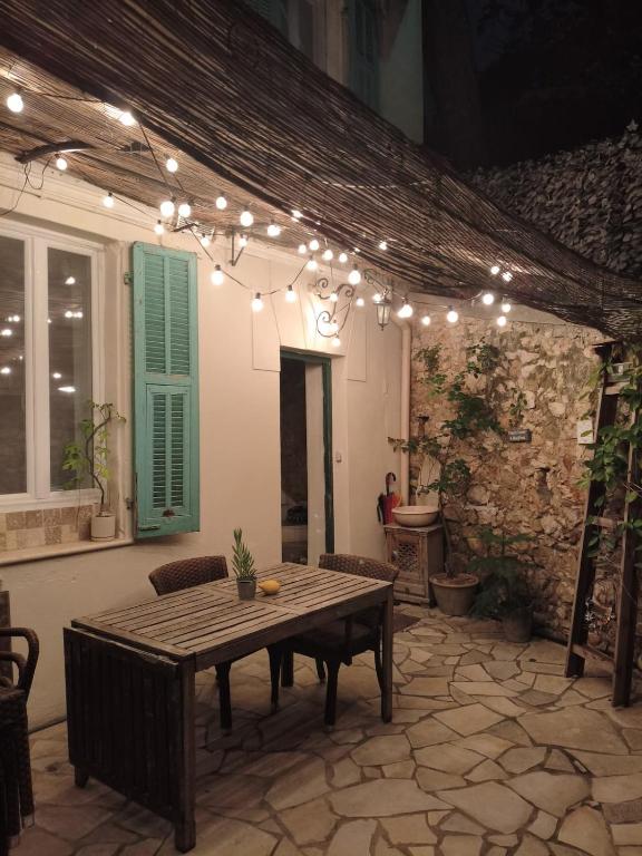 d'une terrasse avec une table en bois éclairée. dans l'établissement Villa central 500m des plages, à Roquebrune-Cap-Martin