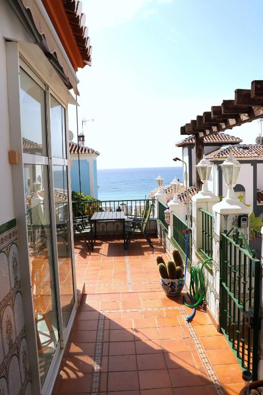 ein Balkon eines Hauses mit Blick auf das Meer in der Unterkunft Charmigt hus med bästa läge i Torrox Costa in Torrox Costa