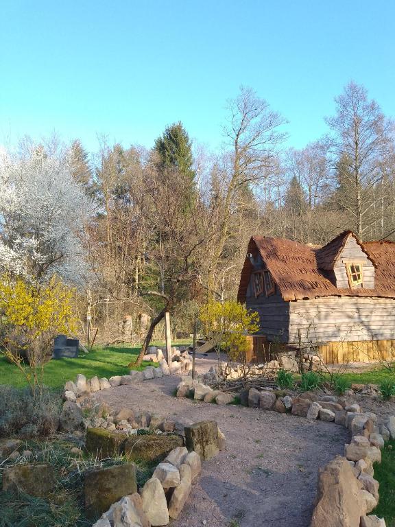 un jardin avec un chemin en pierre menant à une grange dans l'établissement La cabane de Moïra, à Xertigny