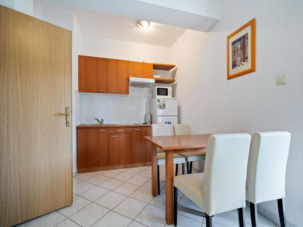 kuchnia i jadalnia ze stołem i białymi krzesłami w obiekcie Panoramic Apartment in Banjole near Pula Town Centre w mieście Banjole
