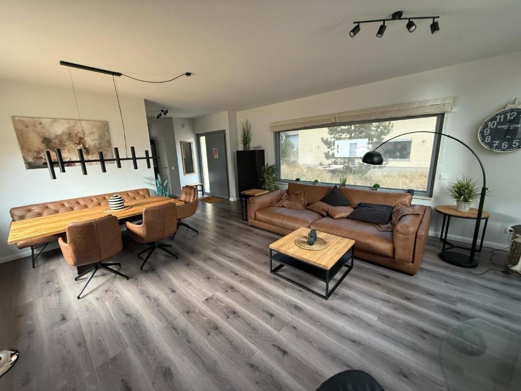 ein Wohnzimmer mit einer Couch und einem Tisch in der Unterkunft Ostsee - Reetdachhaus Nr 42 "Waterkant" im Strand Resort in Heiligenhafen