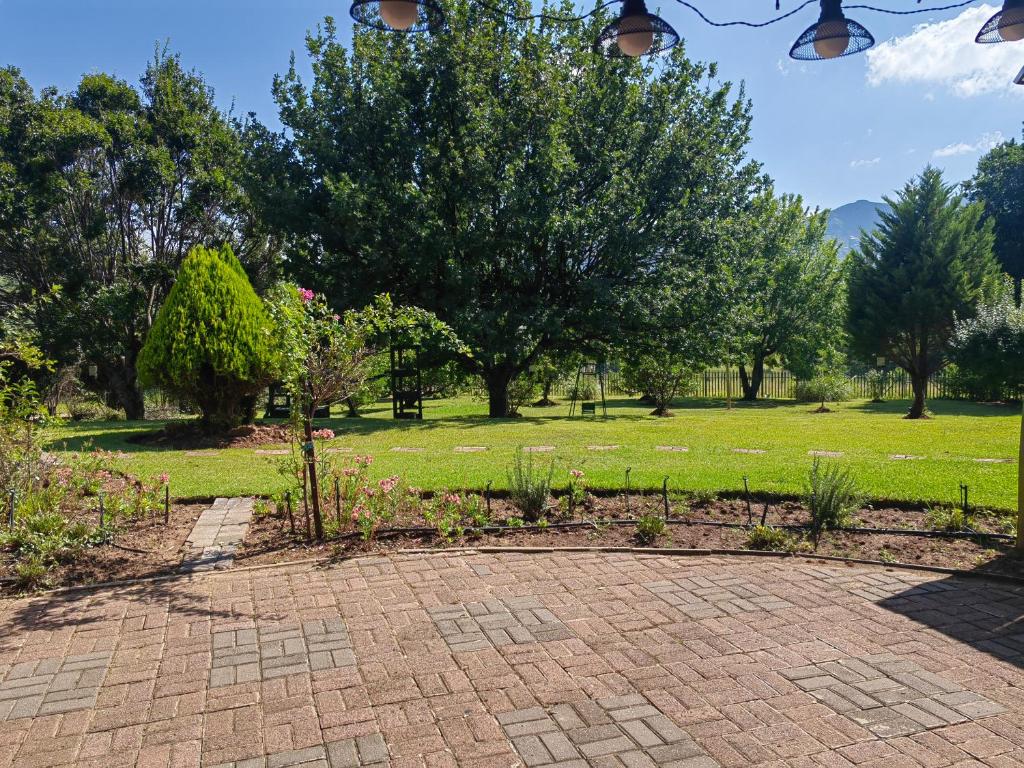 un parco con alberi e un vialetto in mattoni di Palmboom Cottage at Sielerus by Horeb a Clarens