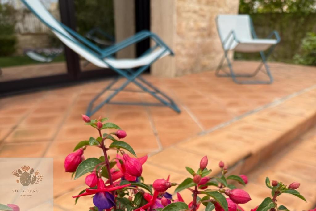 a chair and a potted plant on a patio at Villa Rossi in Polignano a Mare