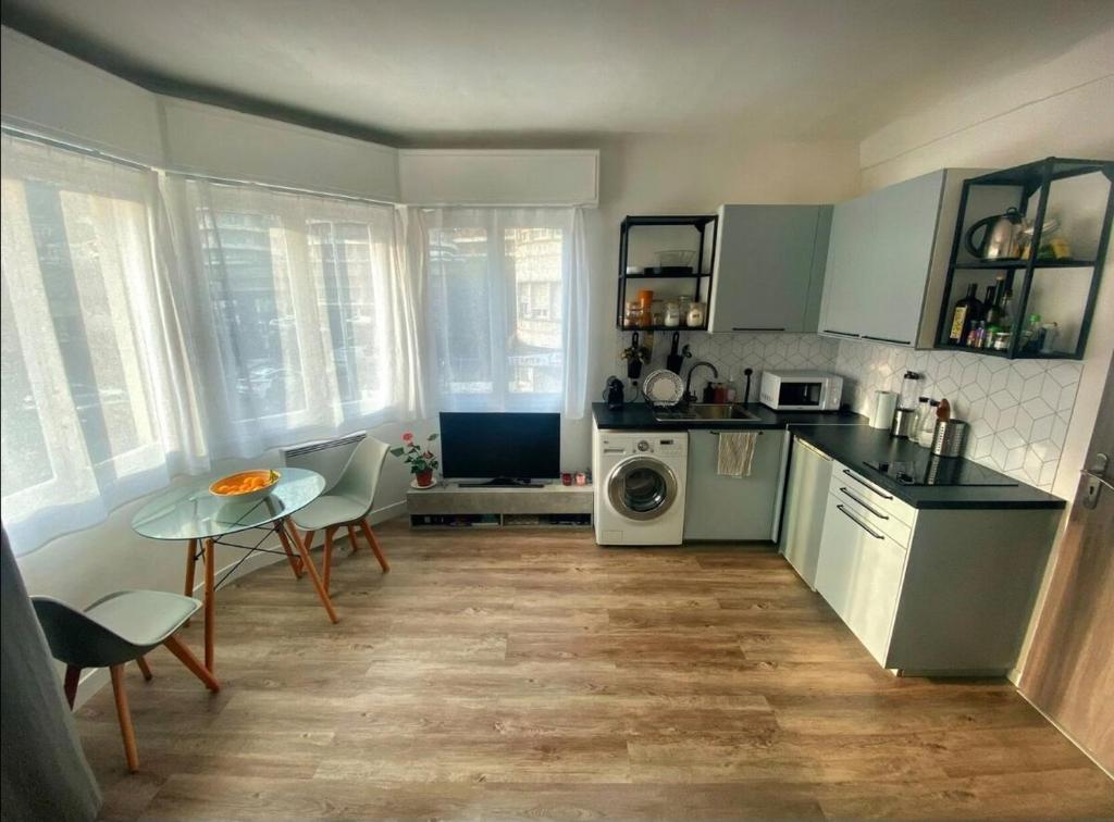 une cuisine avec une table et une table ainsi qu'une cuisine avec une cuisinière dans l'établissement Nice centre studio rénové avec emplacement central, à Nice