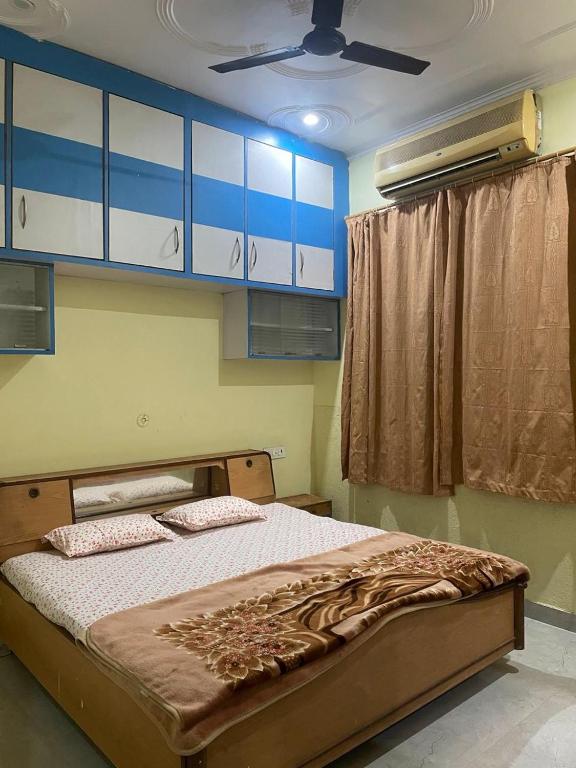 a bedroom with a bed with blue and white cabinets at Cozy Home Stay in Haldwāni
