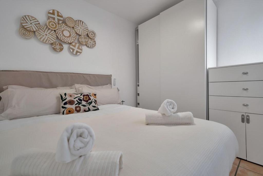 a bedroom with a white bed with towels on it at Casa Andaluza en el centro hisotrico de Estepona - PORTADA 16 in Estepona
