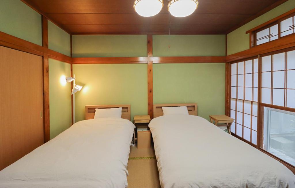 Postel nebo postele na pokoji v ubytování GLOCE sado ベースキャンプ 松ヶ崎 ワンちゃんの家族とも泊まれます