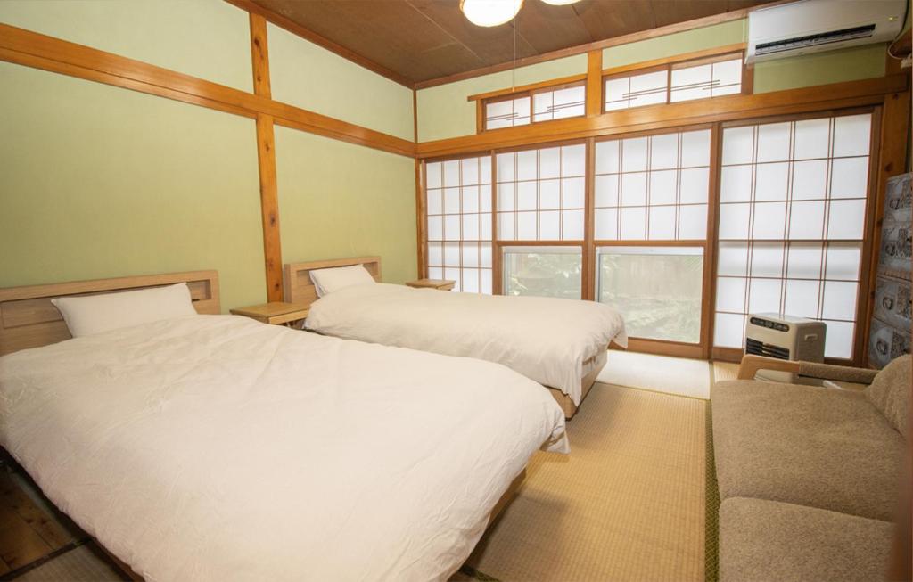 Postel nebo postele na pokoji v ubytování GLOCE sado ベースキャンプ 松ヶ崎 ワンちゃんの家族とも泊まれます