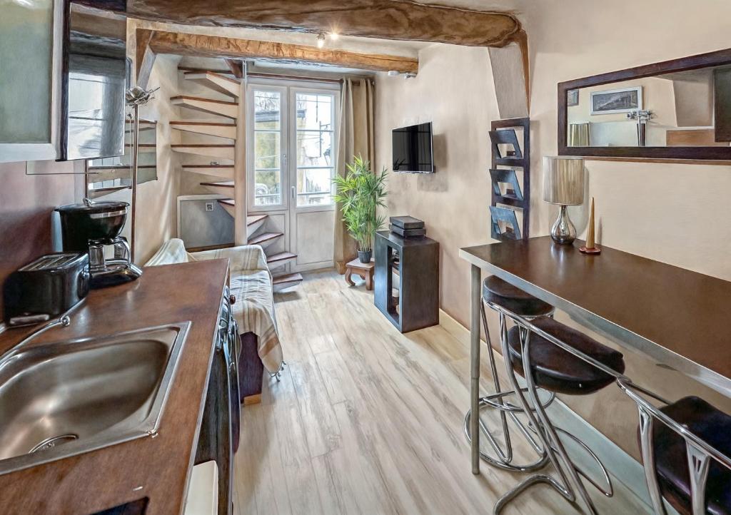 a kitchen with a sink and a living room at T2 charmant avec mezzanine au cœur d'Aix in Aix-en-Provence