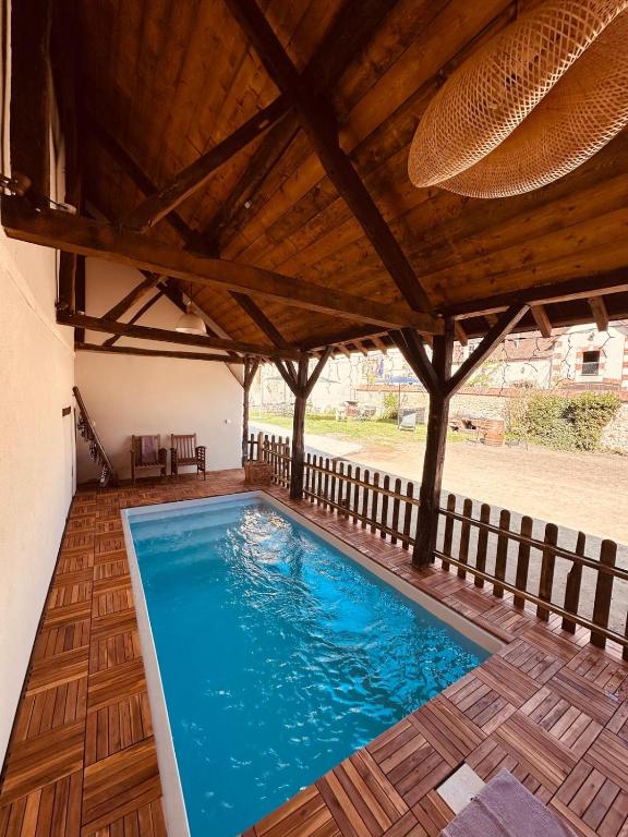- une piscine dans une maison dotée d'un plafond en bois dans l'établissement Maison Henriette, à Léré