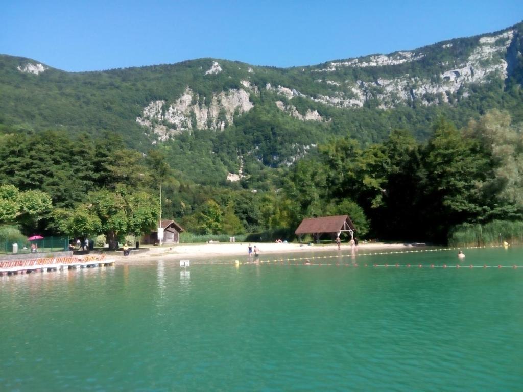 une plage avec une maison au milieu de l'eau dans l'établissement Appart au Lac d'Aiguebelette et Montagne, à Aiguebelette-le-Lac