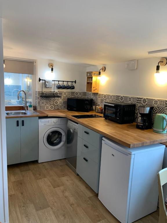 une cuisine avec laveuse et sécheuse dans l'établissement L 'Azuleja, à Fleury-sur-Orne