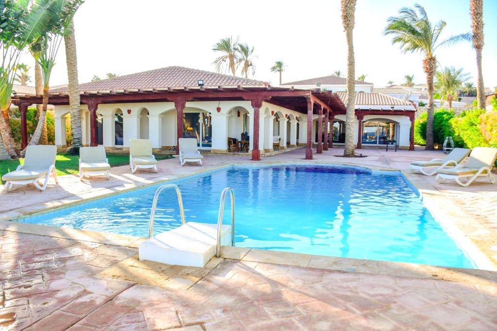 a swimming pool with chairs and a house at villa in Sharm El sheikh2 in Sharm El Sheikh