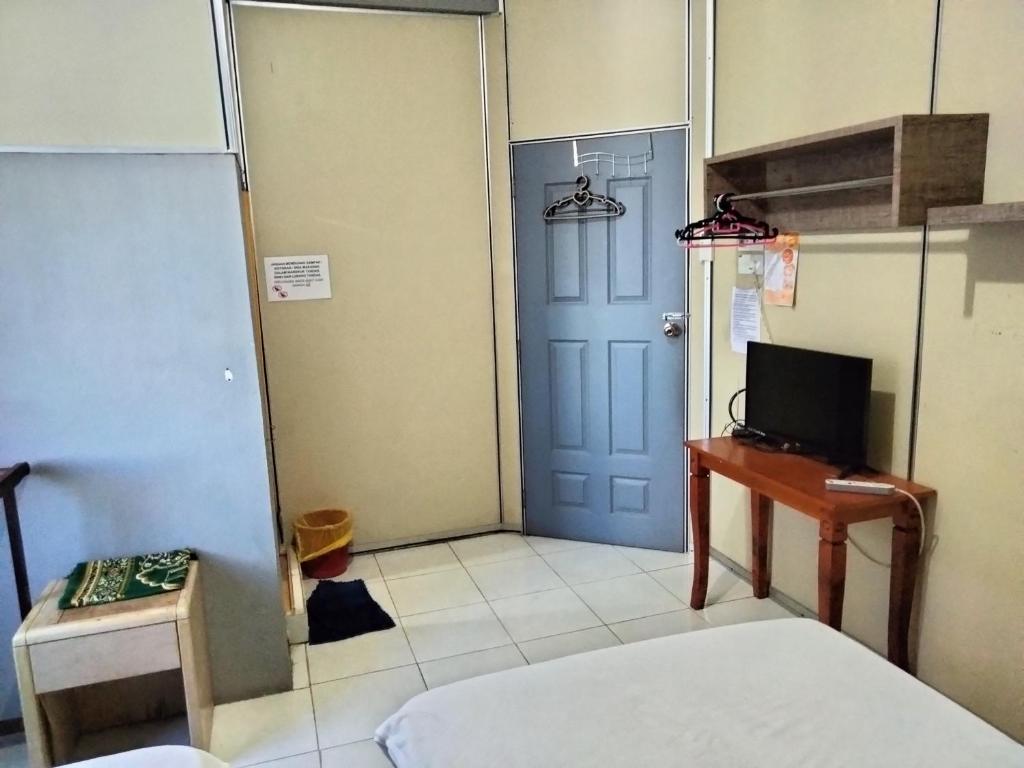 una habitación con una cama y una puerta azul en Hotel Bajet DNOOR Kota Bharu, en Kota Bharu