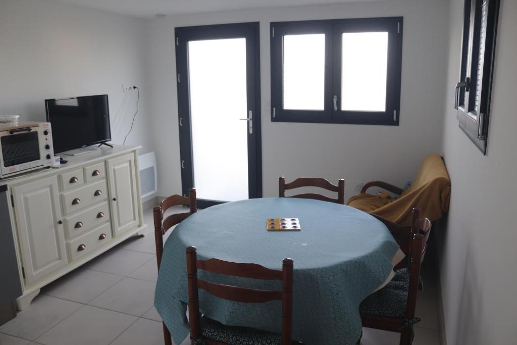 une salle à manger avec une table et une télévision dans l'établissement La Gaubretière, à LʼÉpaux