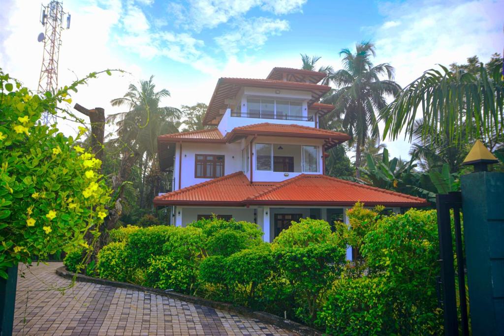 una casa bianca con un tetto arancione su una strada di Janapriya Lake Resort a Polonnaruwa