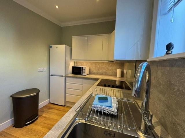 a kitchen with a dish rack on the counter at House in Fort William in Fort William