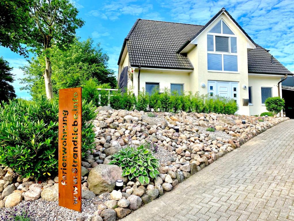 LutterbekFerienwohnung Strandliebe Lutterbek的房屋前有岩石花园的房子