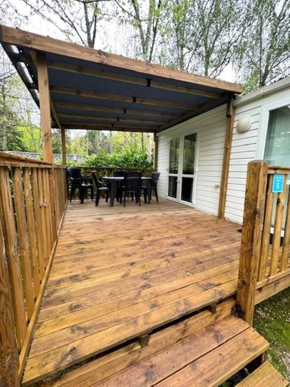 une terrasse en bois avec pergola sur une maison dans l'établissement Camping paradis de la plage, à Saint-Cirq-Lapopie