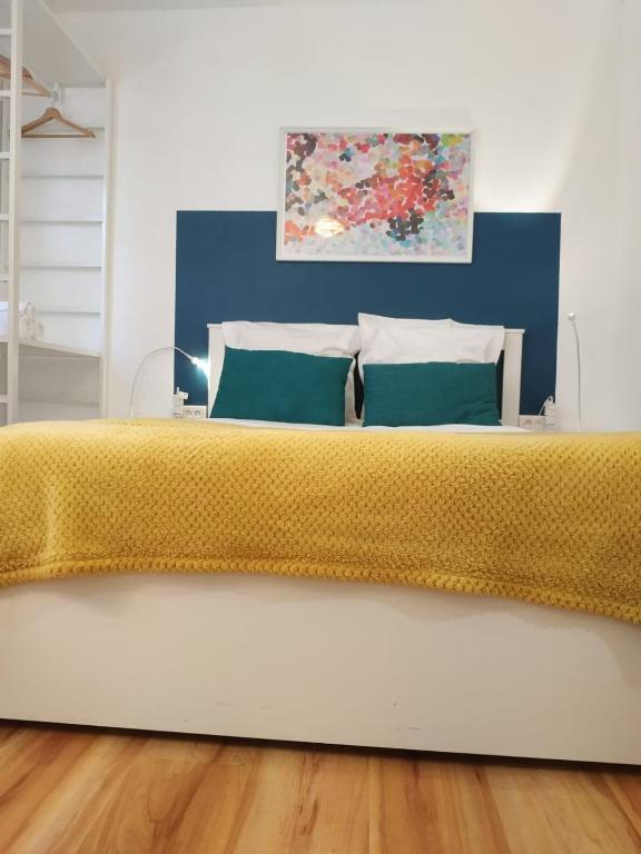 une chambre avec un grand lit avec un couvre-lit jaune dans l'établissement Le Belchamps, Séjour Central entre Gare et Musée, à Metz