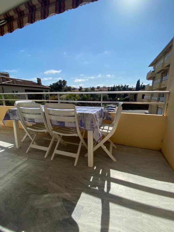 une table et des chaises assises au-dessus d'un balcon dans l'établissement Appartement Fréjus - T3 - 2 chambres - 5 personnes - garage - clim - port à 300 m, à Fréjus