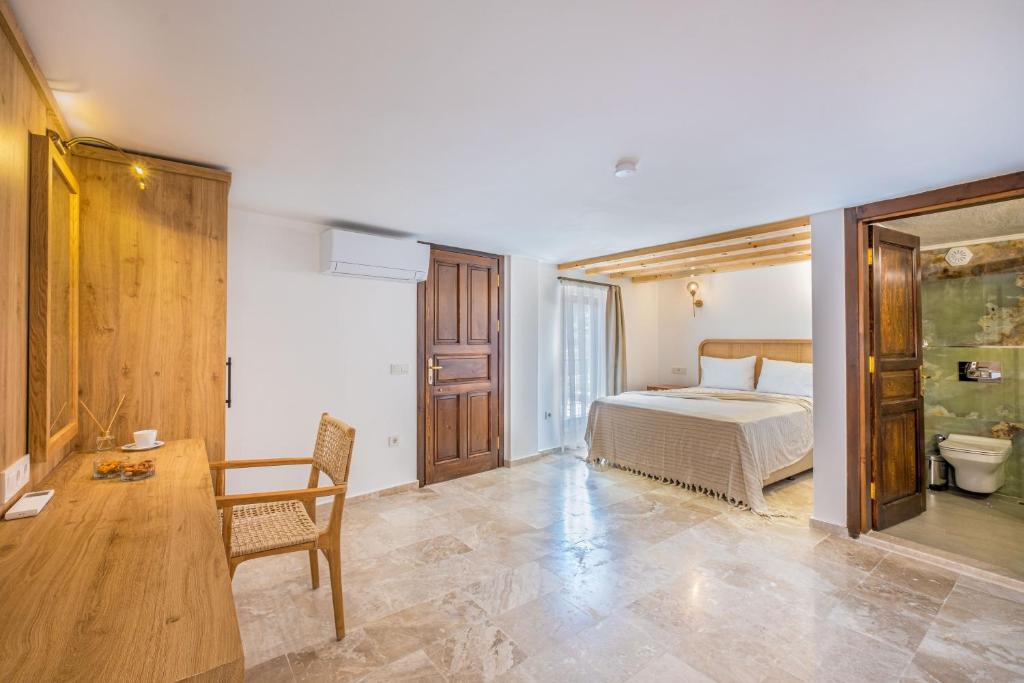een slaapkamer met een bed, een tafel en een toilet bij White Garden Villas Studio Patara in Kas