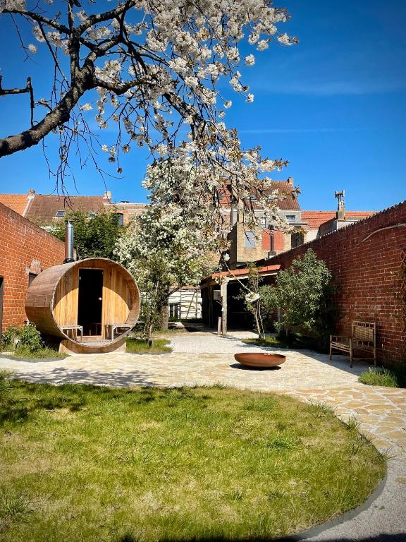 a courtyard with a tree and a bench and a building at Vakantiehuis 'Dune' de panne in De Panne