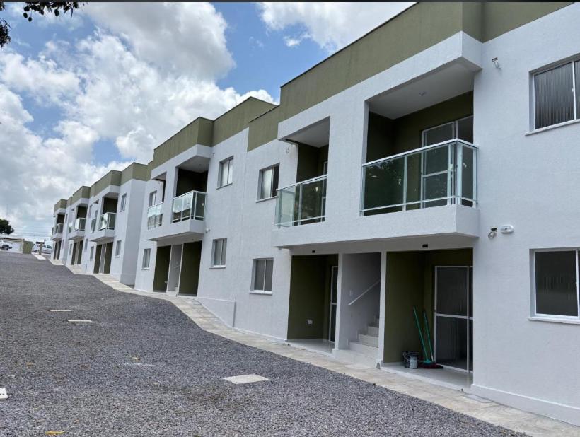 a row of white apartment buildings on a street at Lar caminho da Ilha in Igarassu