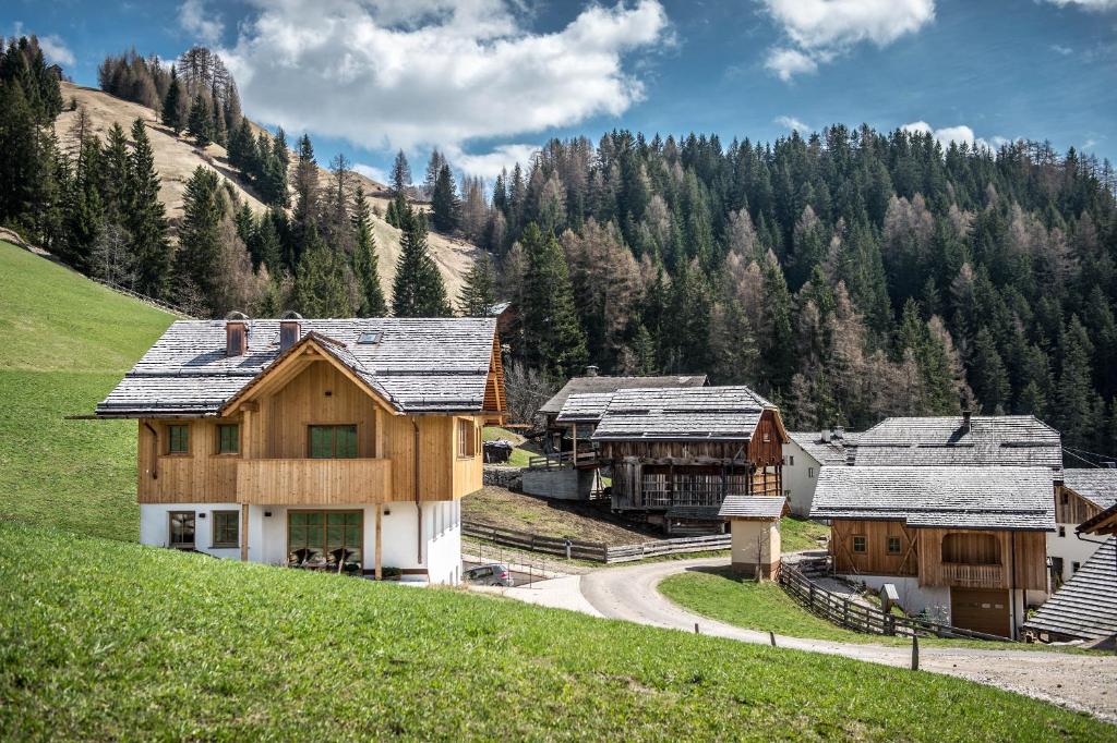 een groep gebouwen op een heuvel met een berg bij Mountain Chalet Pia in La Valle