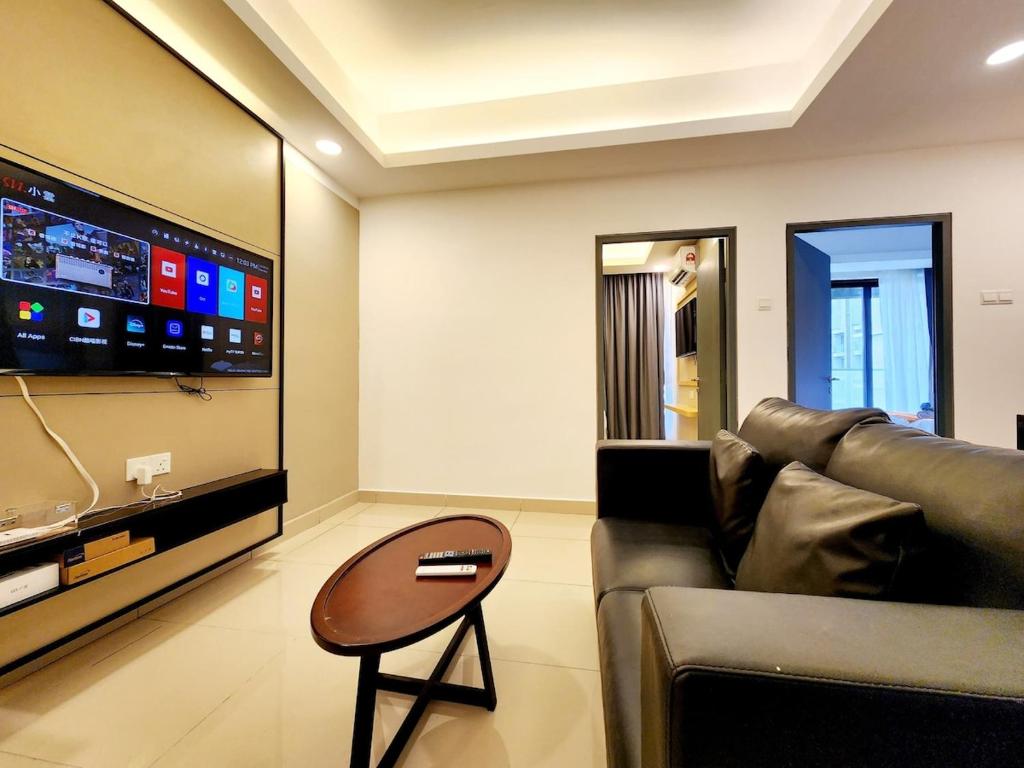 ein Wohnzimmer mit einer Couch, einem Tisch und einem Fernseher in der Unterkunft 10min to Genting 4pax Room Free Parking 1410 in Genting Highlands