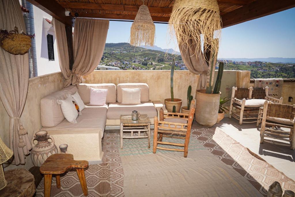 ein Wohnzimmer mit einer Couch und einigen Stühlen in der Unterkunft DAR MUKTAB in Chefchaouen