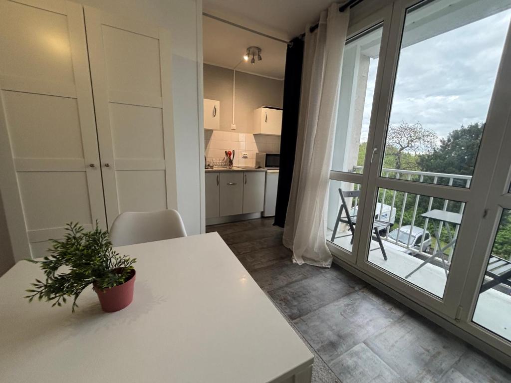 une cuisine avec une table blanche et une grande fenêtre dans l'établissement Studio rénové avec balcon, Calme et lumineux à Tours, à Tours