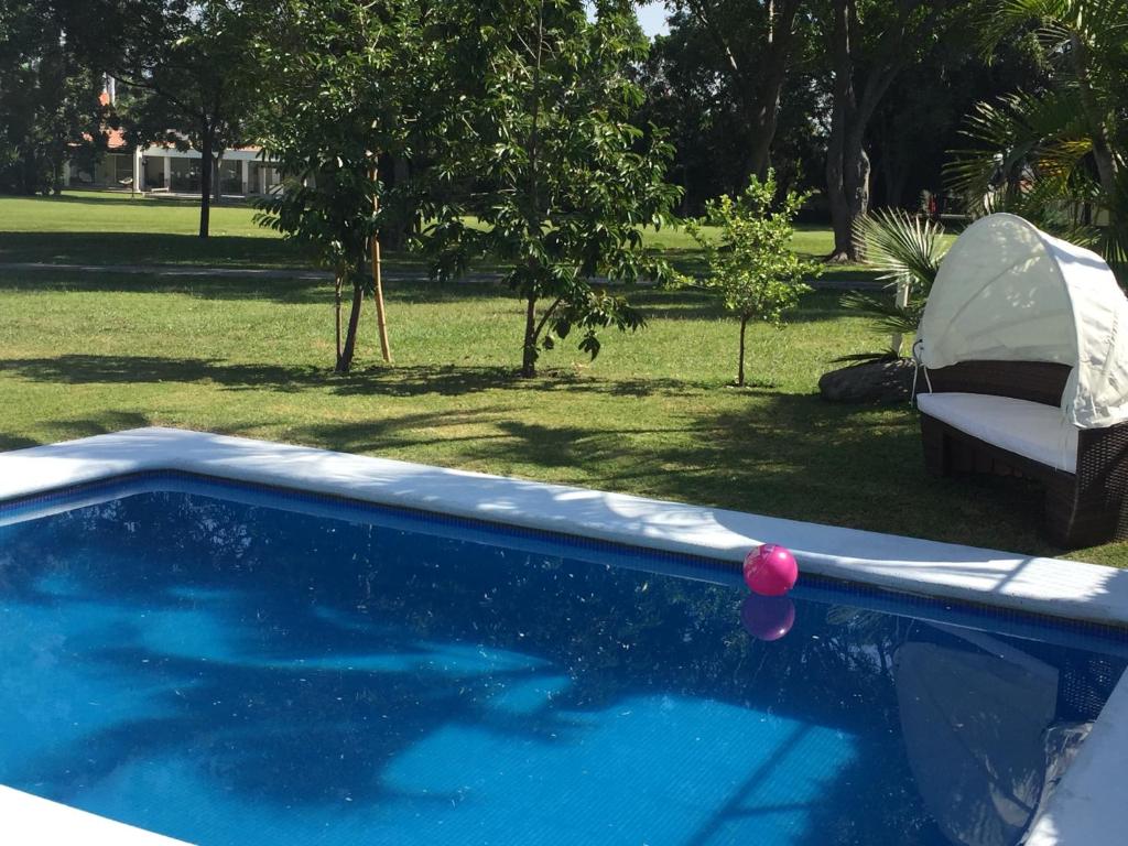 a swimming pool with a red ball in a yard at Casa En Campo de Golf, Lomas de Cocoyoc in Texcalpan