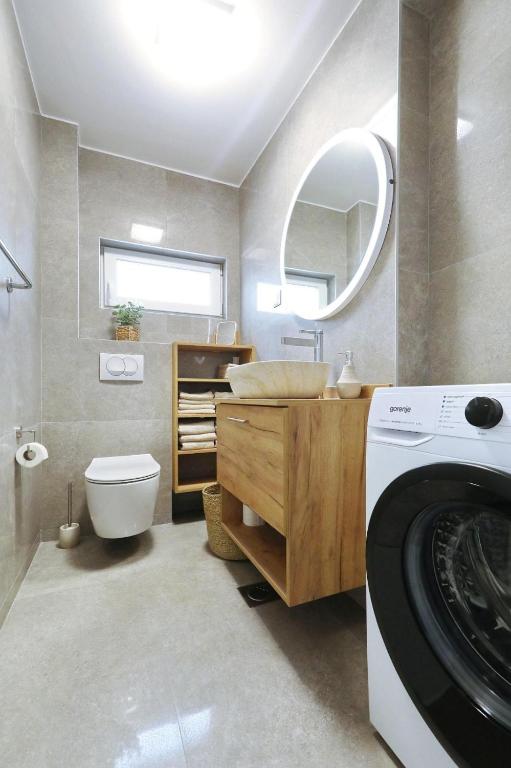 a bathroom with a washer and dryer in it at Apartmani Cicak in Vir