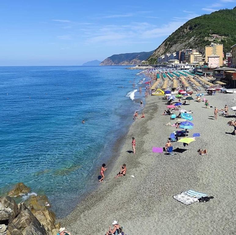 Un grupo de personas en una playa con el océano en Casa Milo, en Deiva Marina