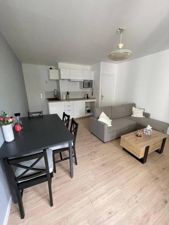 un salon avec une table et un canapé dans l'établissement Charmant T2 rénové à neuf, à Saint-Hilaire-de-Riez