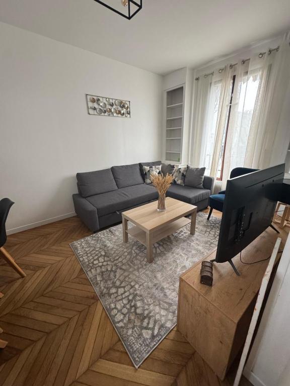 un salon avec un canapé et une table basse dans l'établissement Spacieuse maison, CDG, Astérix, Disney, Paris, à Stains