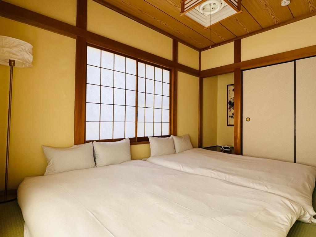 東京にあるLucky you! TATEISHIの窓付きの客室で、白い大型ベッド1台が備わります。