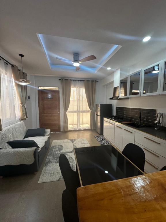 a kitchen and living room with a ceiling fan at Hero House in Pooc