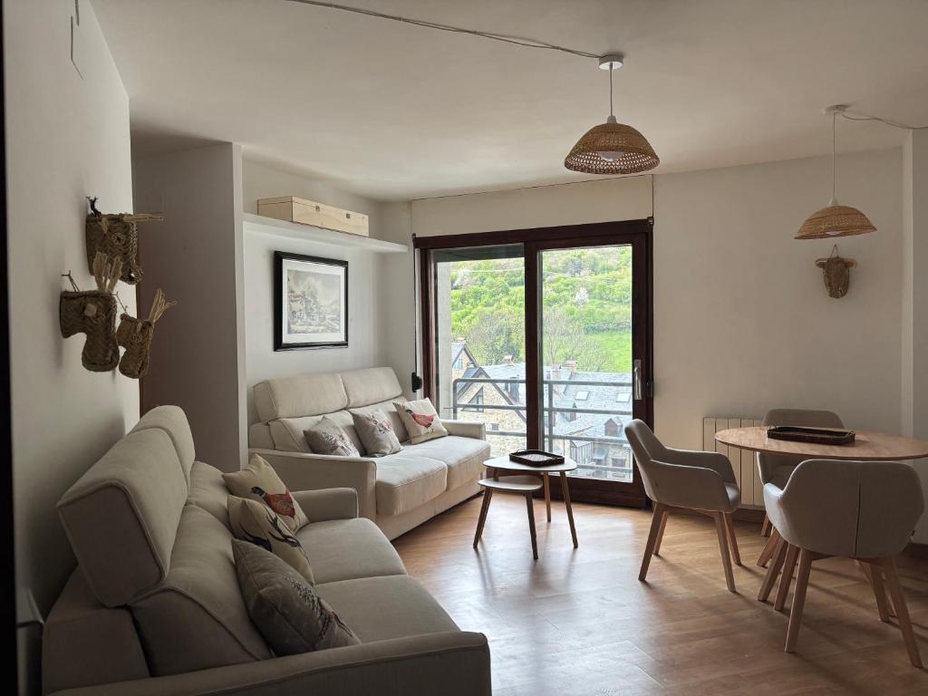 ein Wohnzimmer mit Sofa und Tisch in der Unterkunft TUCA - Apartamento en Vielha in Vielha e Mijaran