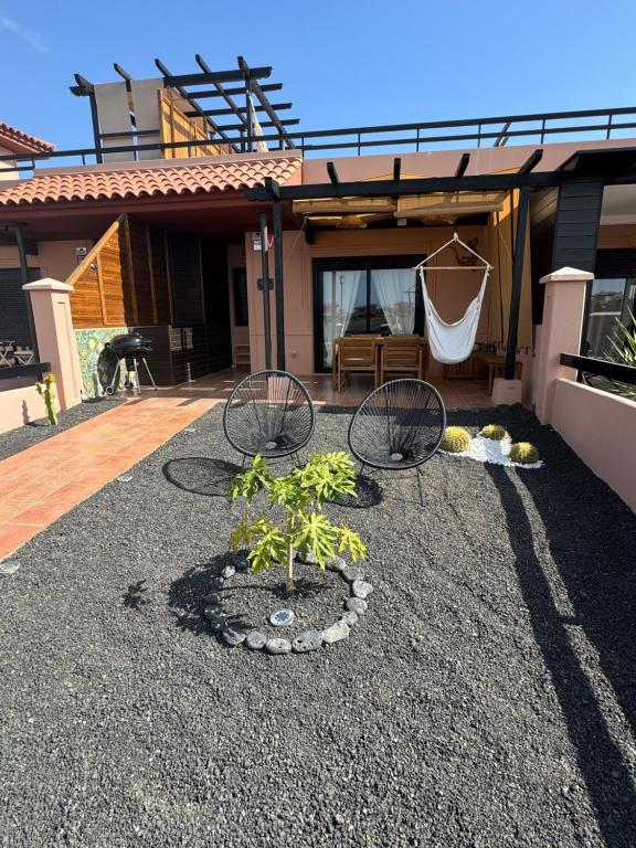 a patio with two chairs in front of a house at Villa Miraki Fuerteventura Surf Relax in La Oliva