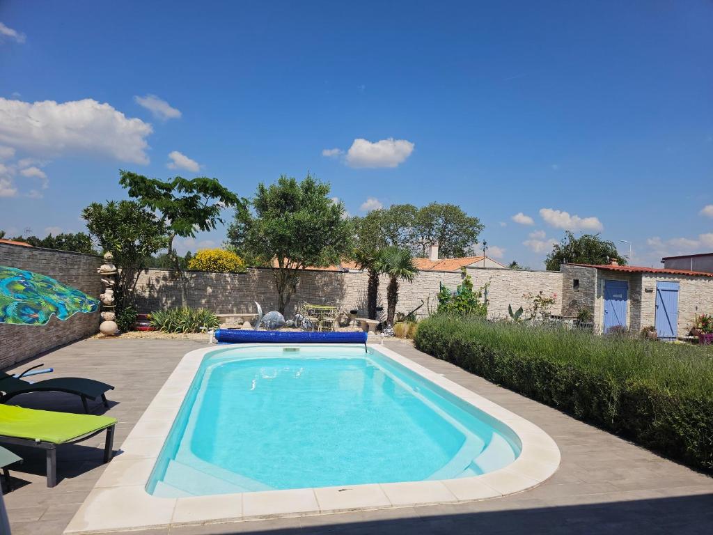 a swimming pool in a yard with a patio at maison piscine clos ,wifi, 2 chambres près de la mer in Bourgneuf-en-Retz