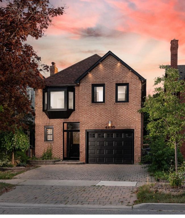 a brick house with a black garage at Beautiful and cozy unit in Mississauga