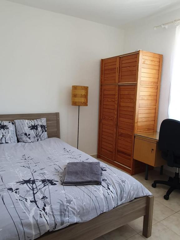 une chambre avec un lit, un bureau et une chaise dans l'établissement Chambre Proche Plage du Prophète, à Marseille