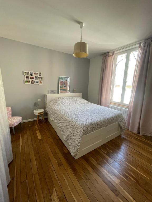 une chambre avec un lit et un parquet dans l'établissement Maison & ses 2 chats, au Mans