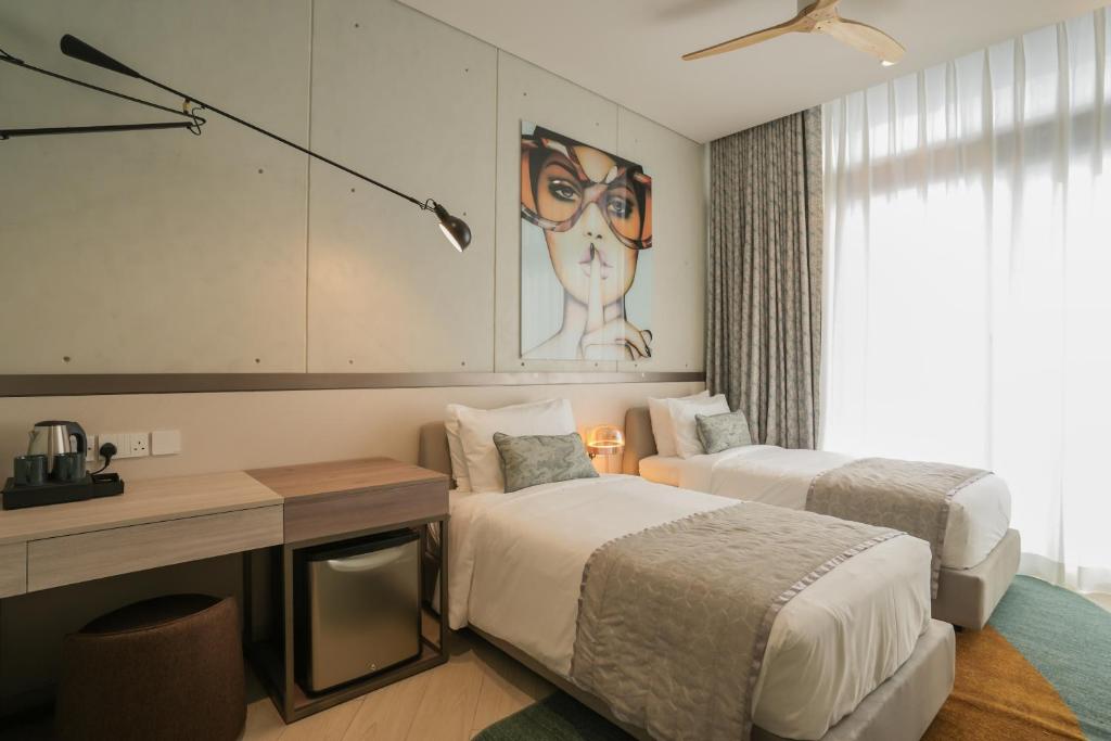 コロンボにあるSeSaya Poshtel & Bistroのベッド2台と机のあるホテルの部屋