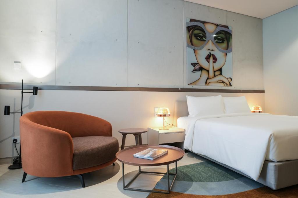 コロンボにあるSeSaya Poshtel & Bistroのベッドと椅子付きのホテルルーム