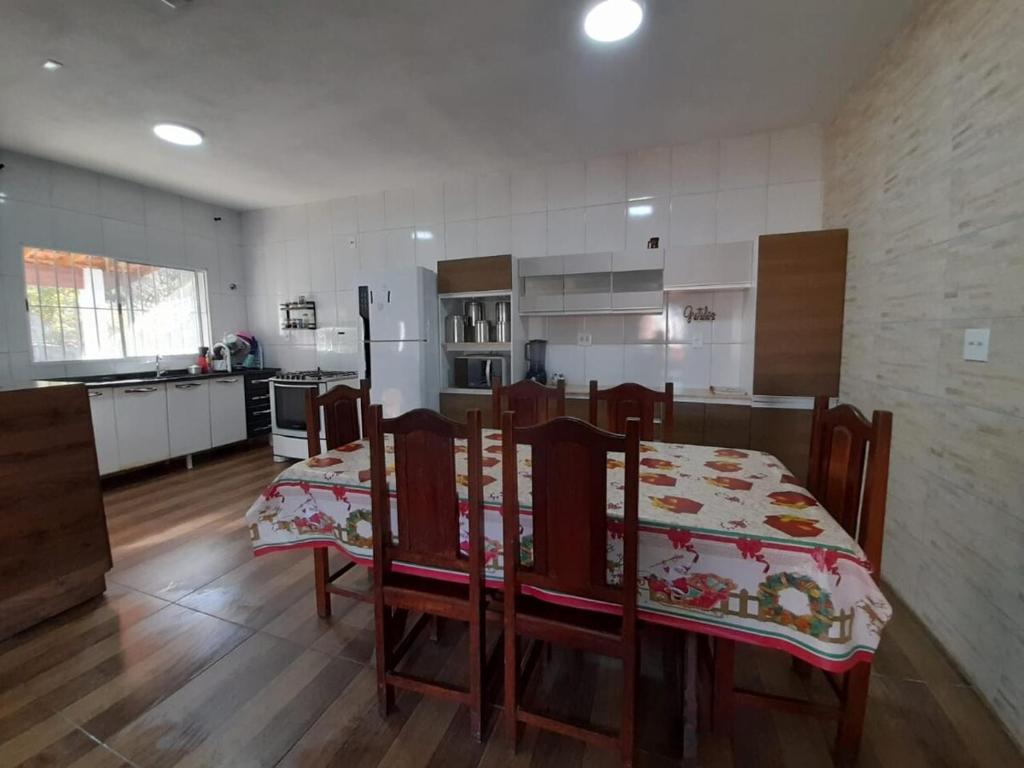 une cuisine avec une table et des chaises dans une pièce dans l'établissement Chácara Fazendinha Oliveira, à Mogi das Cruzes