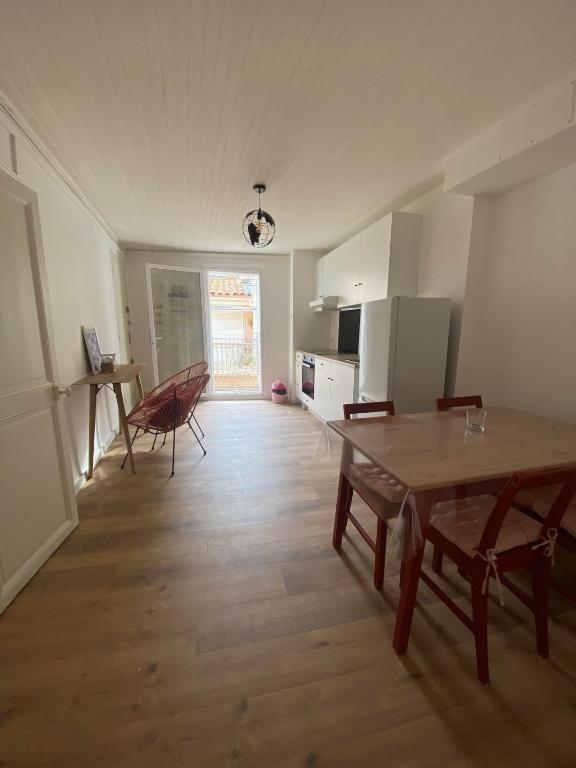 un salon avec une table et une cuisine dans l'établissement Bright apartment in the historic center, à Marseillan