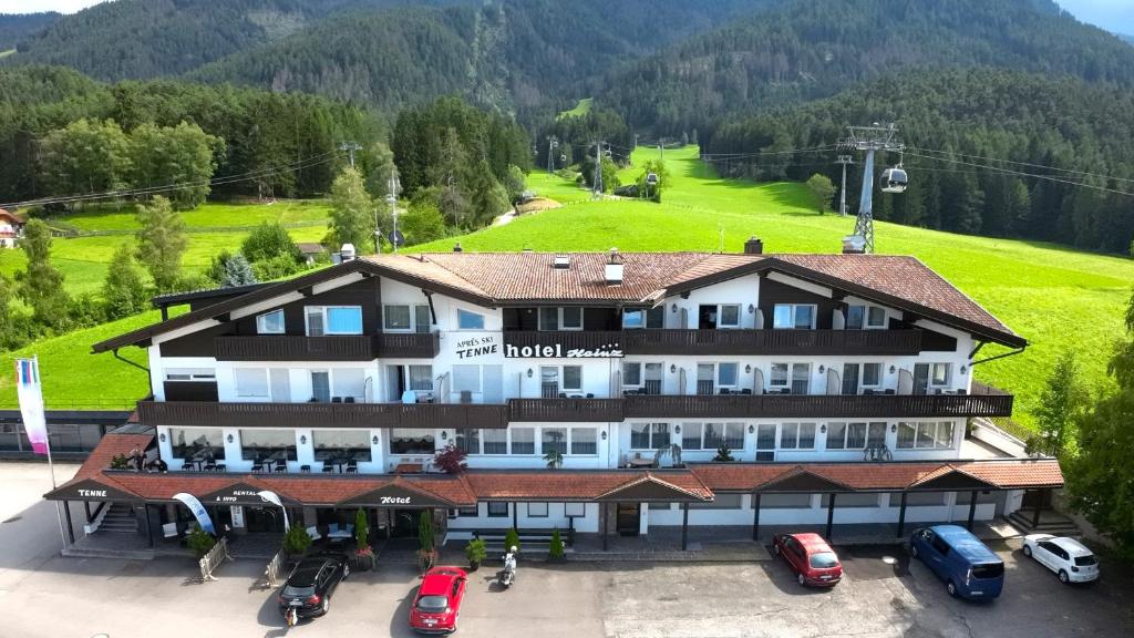 un grande hotel con auto parcheggiate in un parcheggio di Hotel Heinz a Brunico